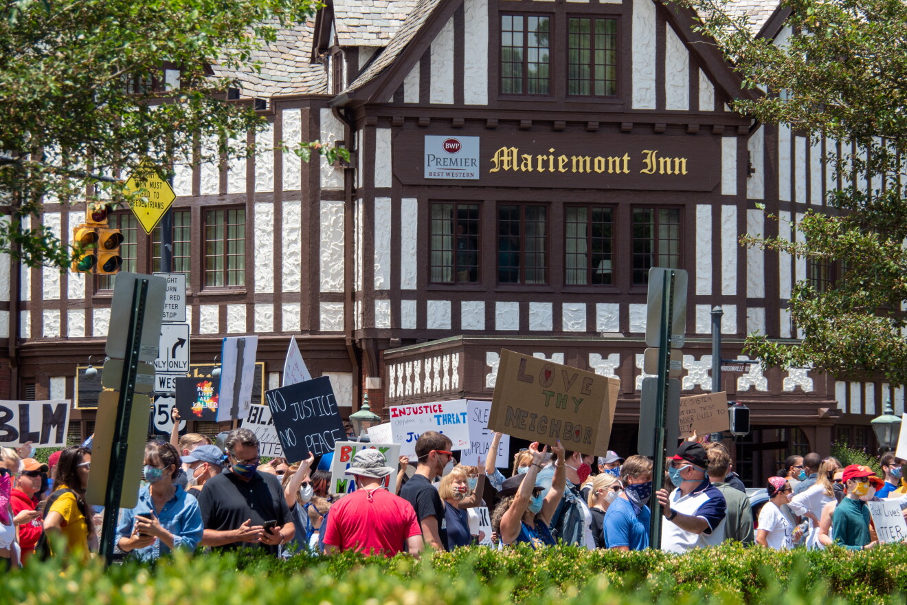 People hold up signs in support of the Black Lives Matter movement outside the Mariemont Inn on Sunday, June 14.